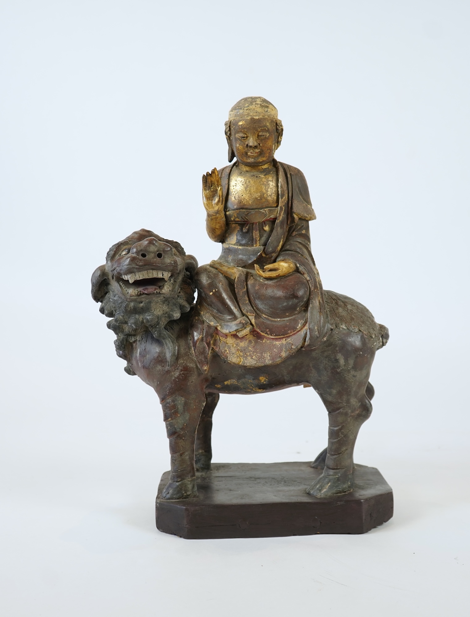 A Chinese gilt and polychrome lacquered stucco work and wood figure of Manjushri on a lion, Yuan-Ming dynasty